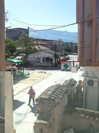 view out the front window onto the street with the mountains in the distance.